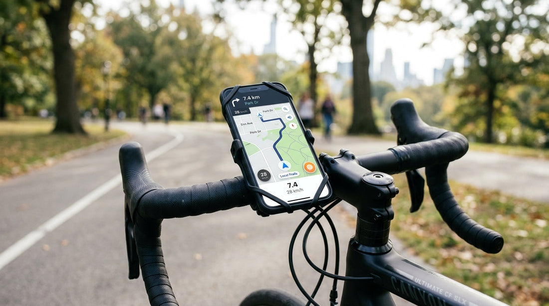 Black slab-style smartphone mounted in a black silicone universal handlebar phone mount on a road bike, showing a cycling navigation map on the screen